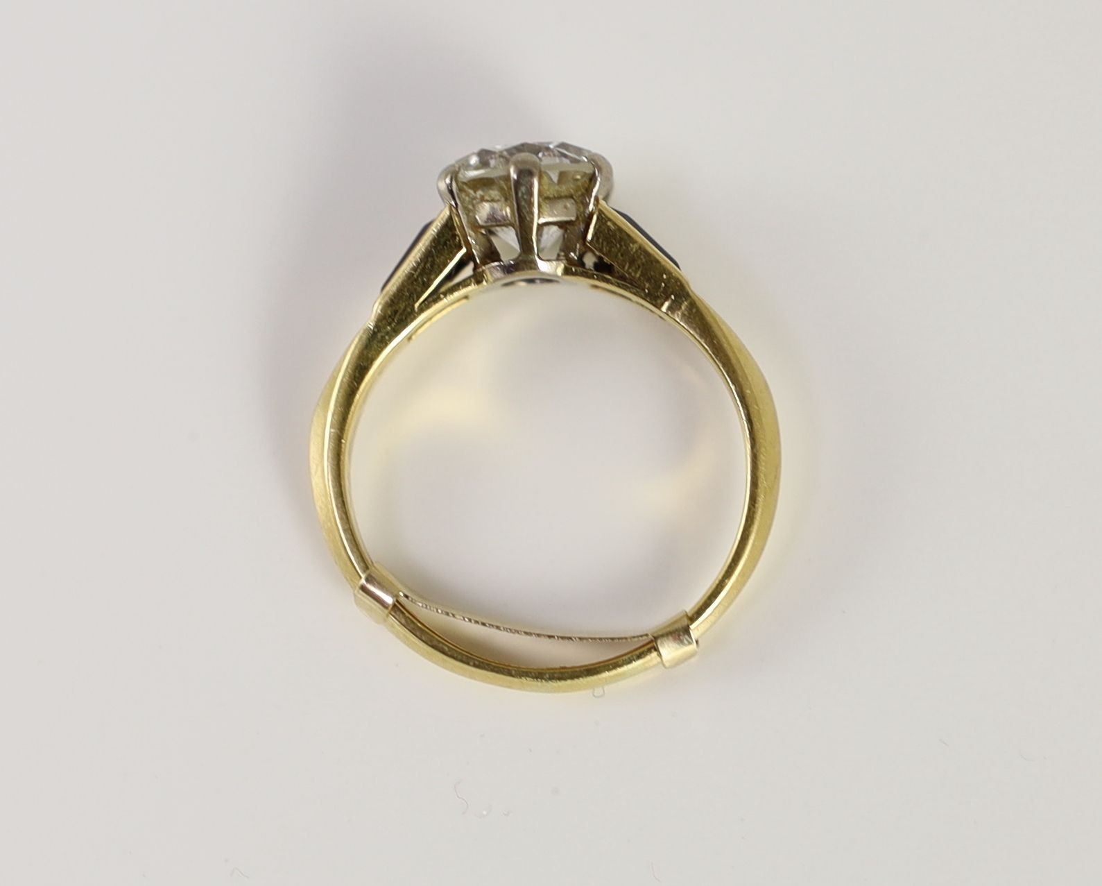 A modern 18ct gold and single stone diamond ring, with trapeze cut sapphire set shoulders